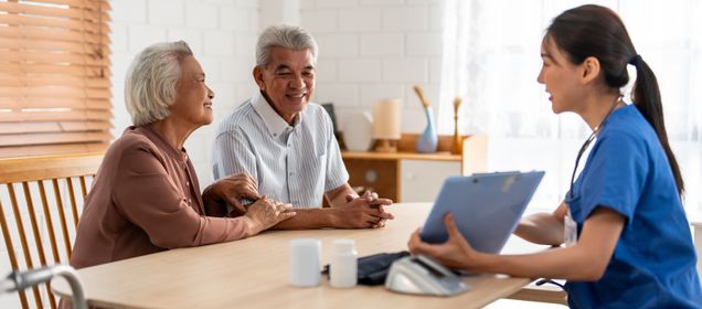 Caregiver nurse examine senior man and woman patient at home.