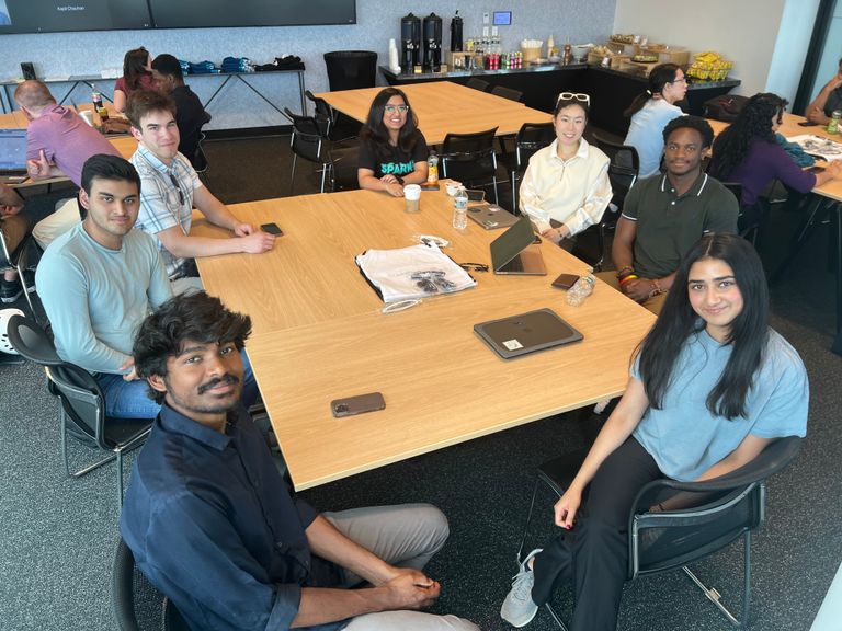 Photo of students sitting around table collaborating