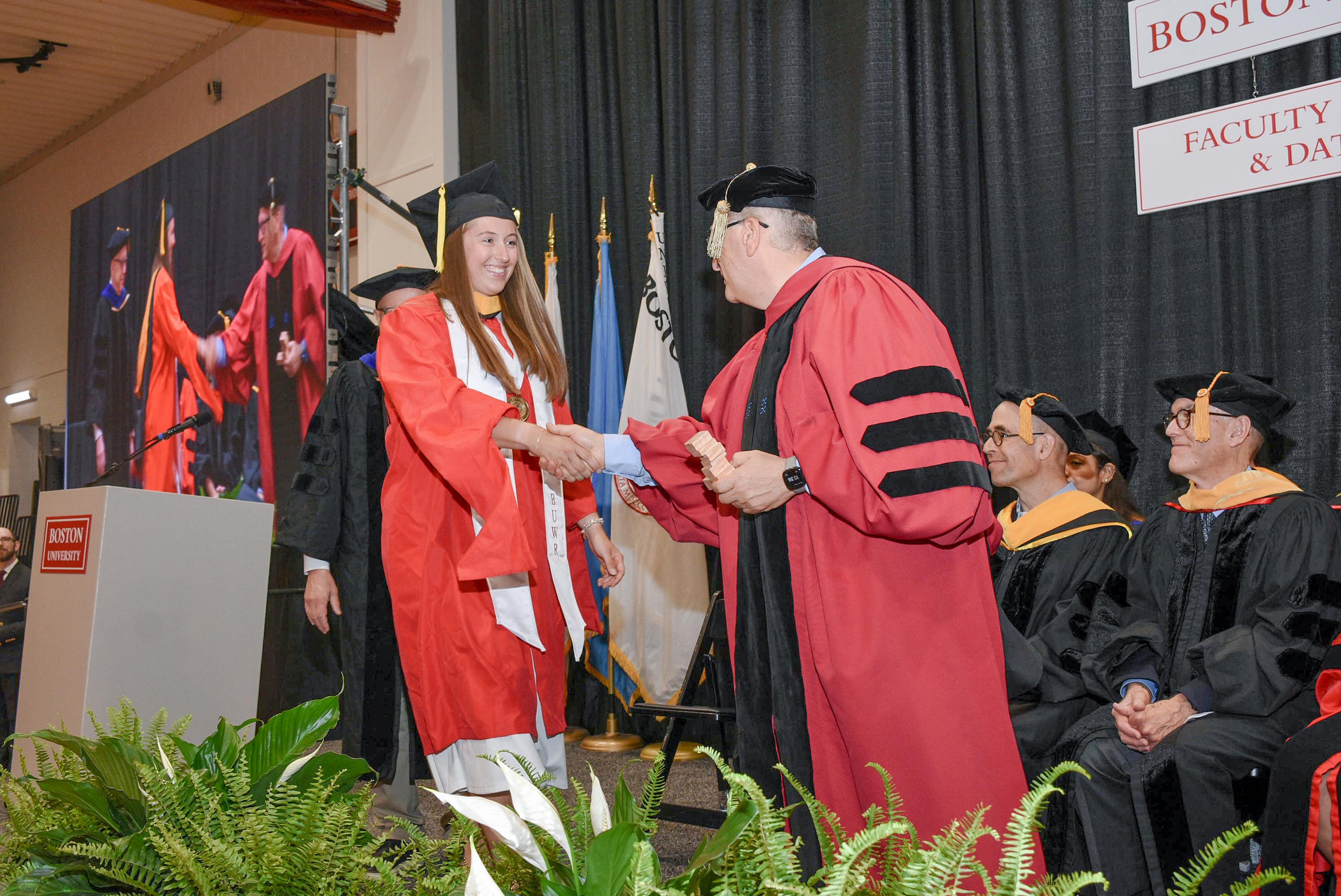 Photo of CDS Graduate student shaking hands with Azer Bestavros, Associate Provost of Boston University Faculty of Computing & Data Sciences