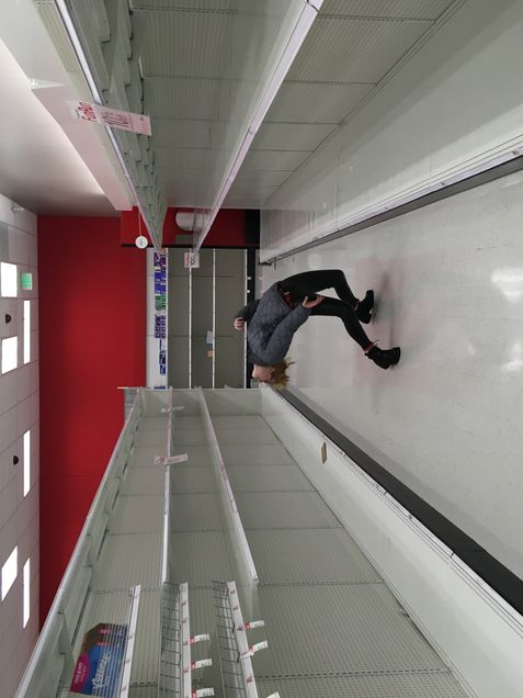 a boy standing in an empty aisle of Target