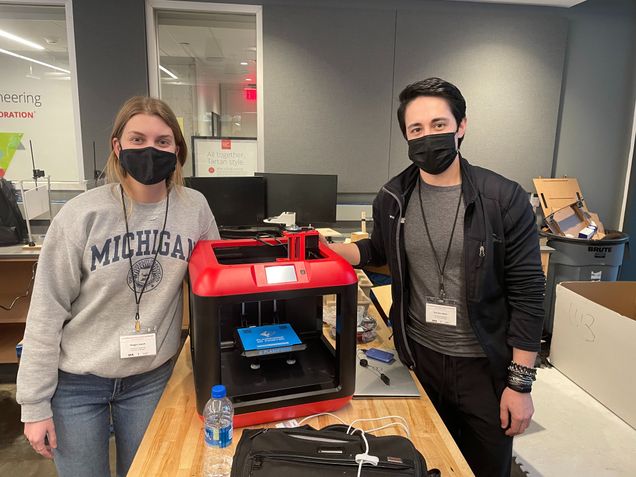 Professor Baker and student stand next to 3d printer