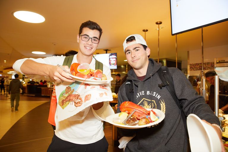 students showing thier plates of lobster at lobster night in the dinning haal