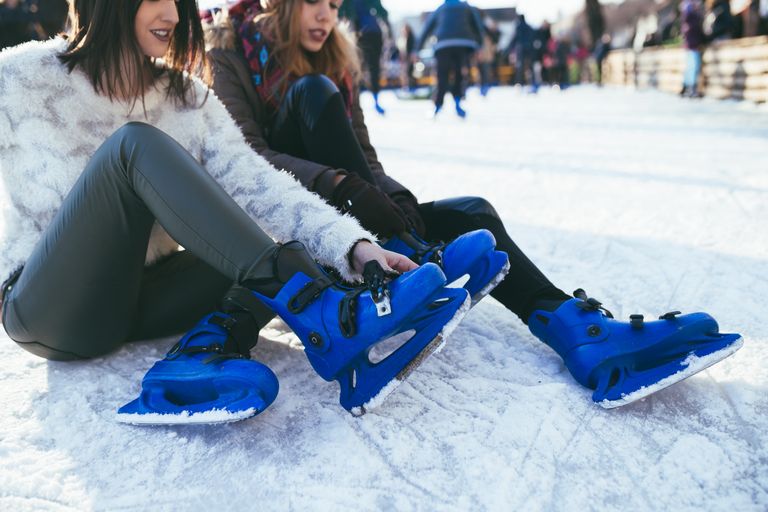 2 women on skates at ice-skating rink.