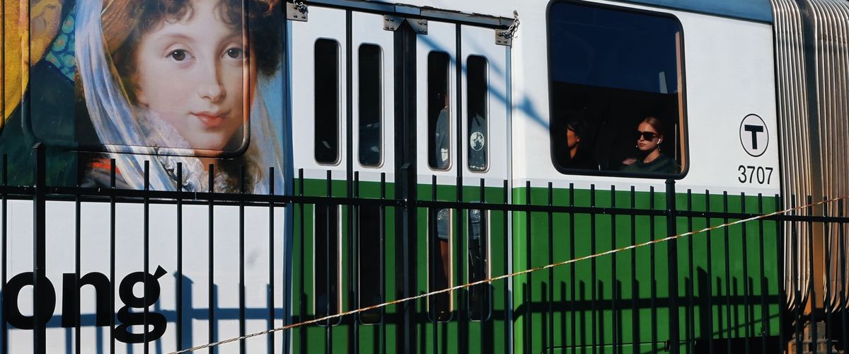 photo of woman in sungalsses looking out the window of the green line train