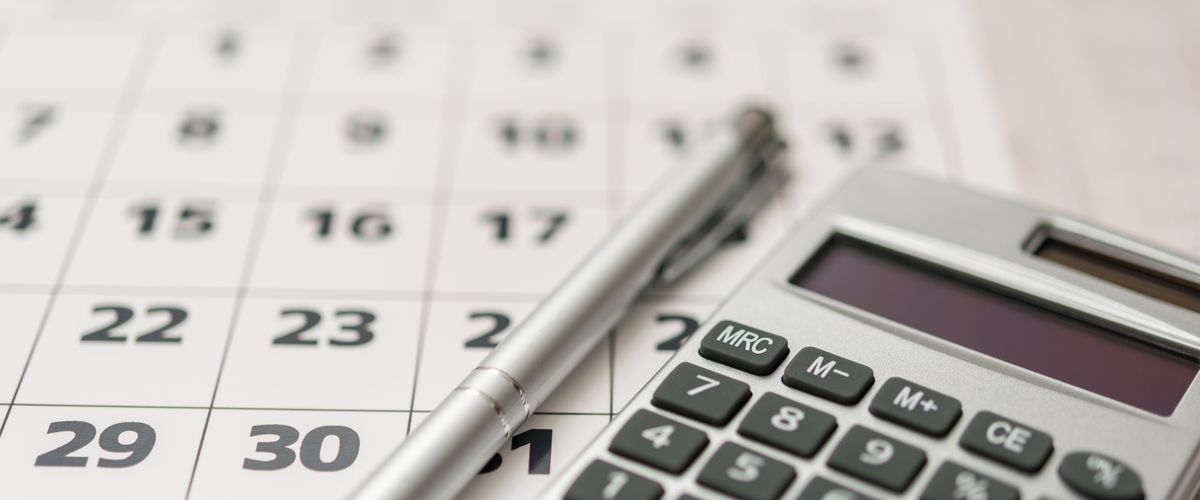 Photo of calendar, pen and calculator