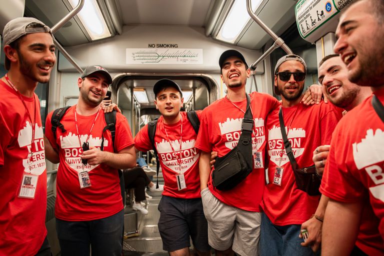 Group of male CELOP student on a green line trolley