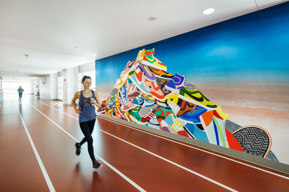 Josef Kristofoletti (’07) designed the vibrant mountain of sneakers, titled Sneakerman, on the wall of the indoor running track at the BU Fitness & Recreation Center