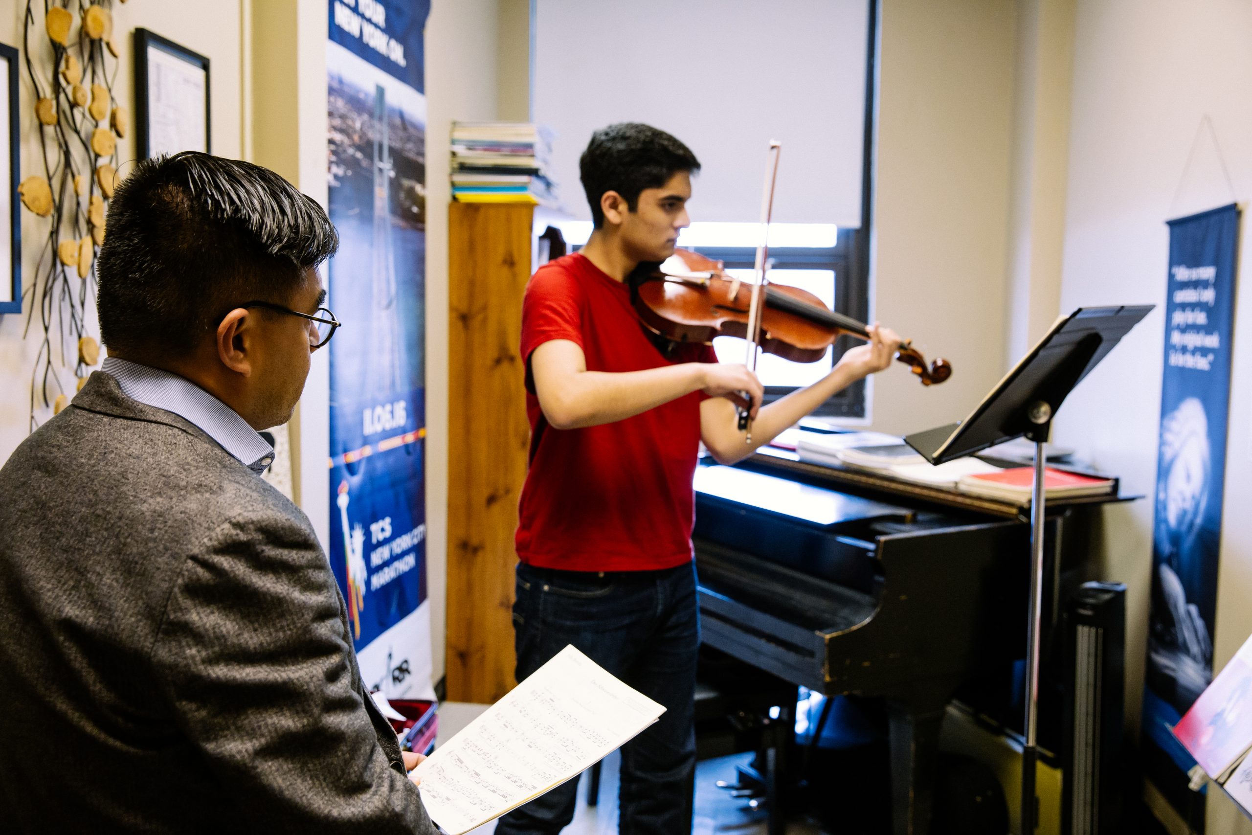 Music instructor watching student play the violin