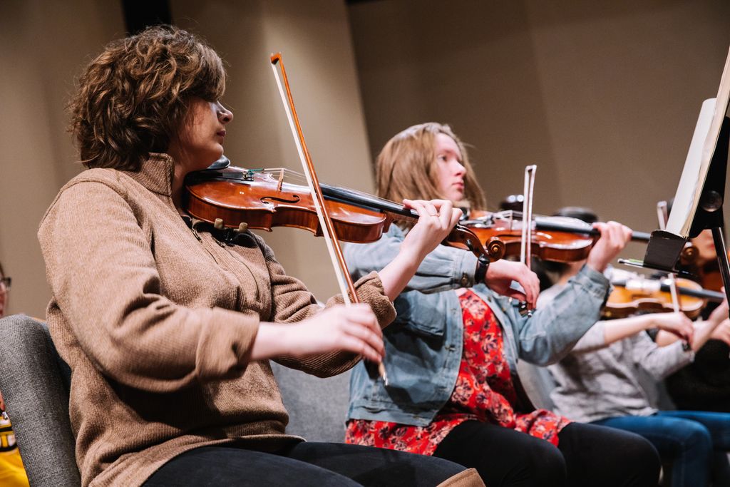 Music student playing the violin at concert