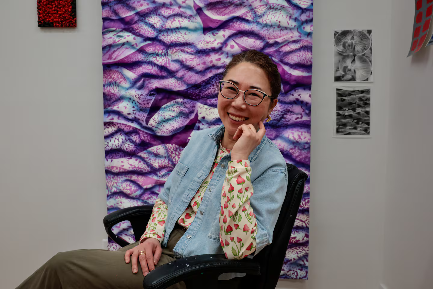Artist Lucy Kim poses for a portrait with a sculptural painting at her studio in Somerville