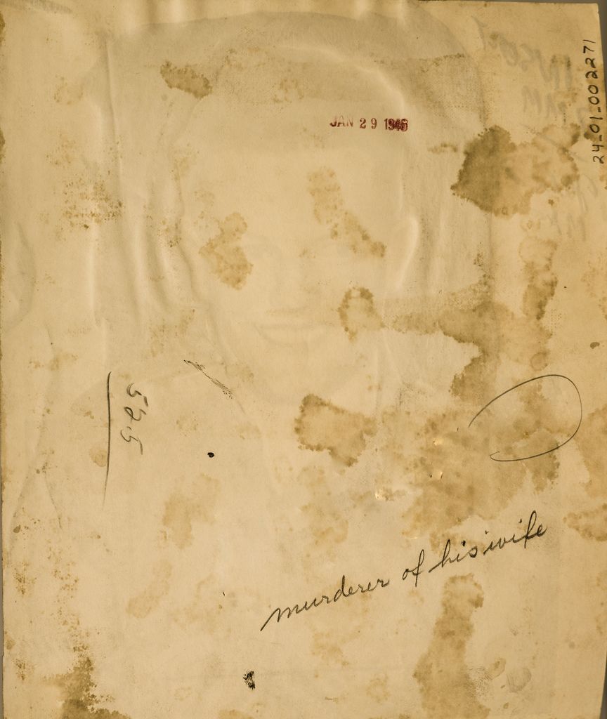 An aged and stained piece of paper featuring handwritten text that reads "murderer of his wife" along with other unclear markings and numbers. The paper shows signs of discoloration and wear, with several brown spots and smudges scattered across its surface. There is also a faded red stamp with a date partially visible as "JAN 29 1945."