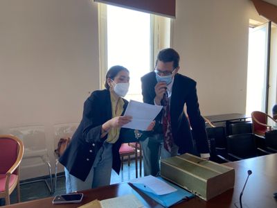 two individual looking at a paper and discussing