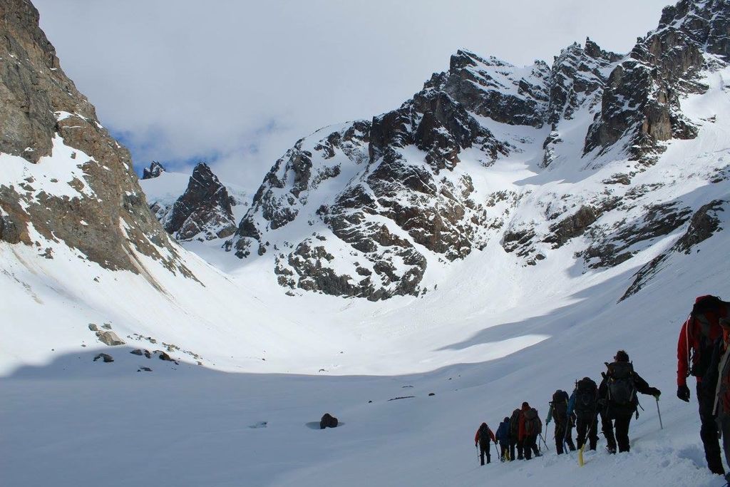 A group of hikers making their way to a snow-covered mountain