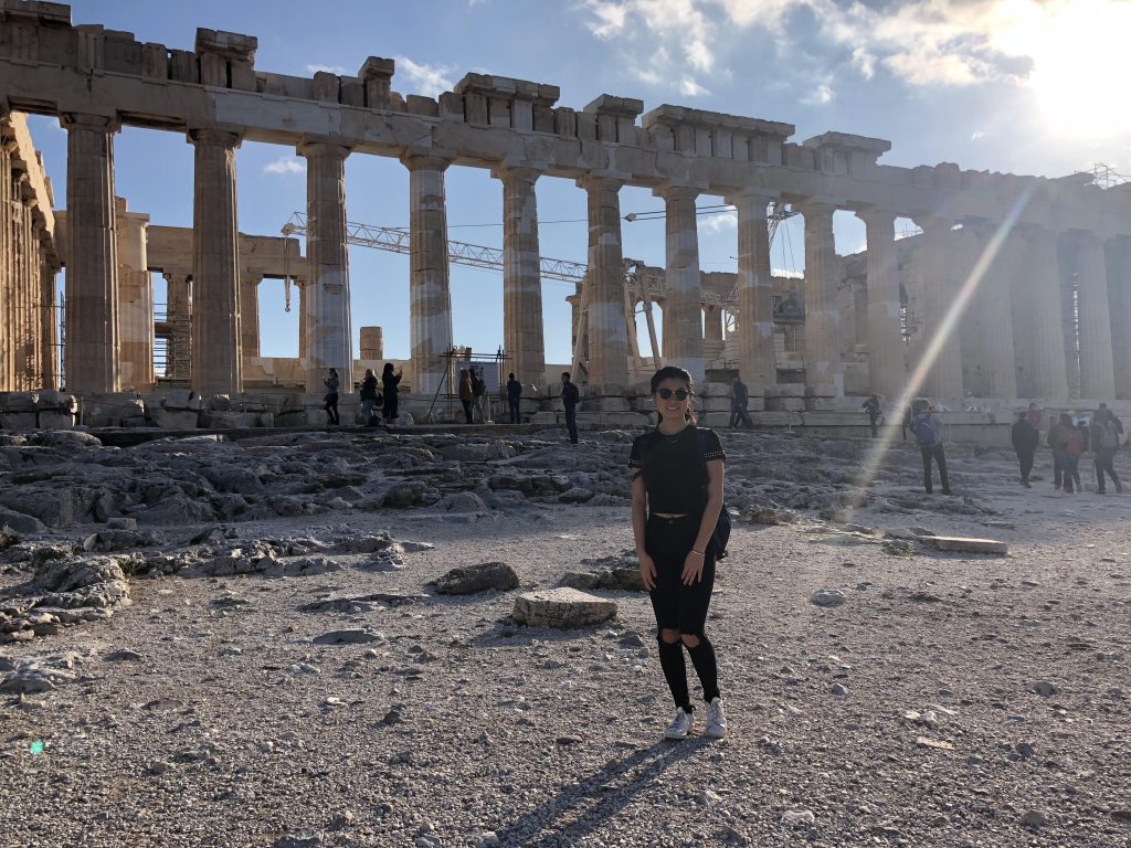 Julia Kim in Greece, with ancient ruins and pillars behind her