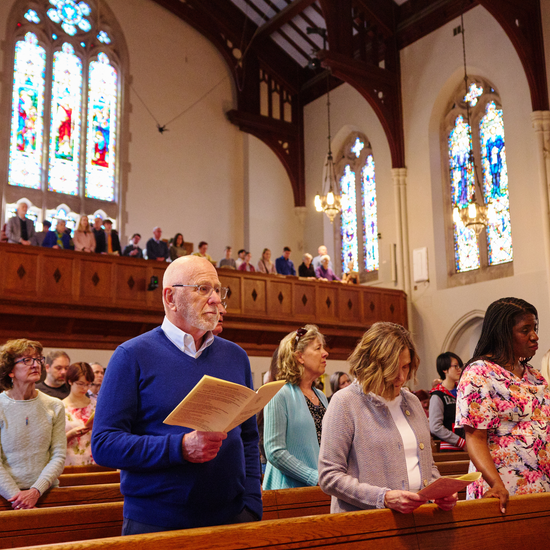 Members of the congregation standing for a hymn at a worship service in the Marsh sanctuary