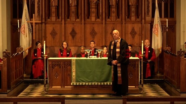 Dean Hill standing in front of the altar preaching a sermon