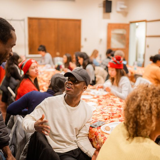 Students converse around tables over a meal in the Marsh Room