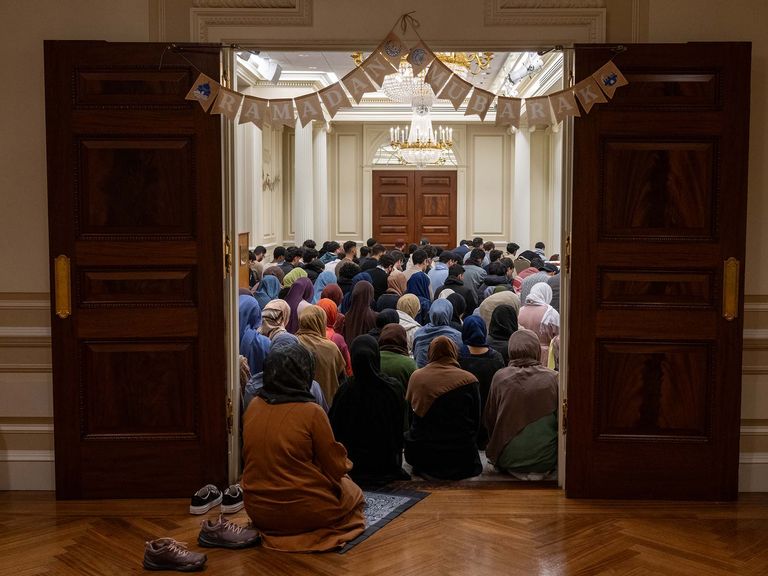 muslim brothers and sisters perform Ramadan prayers in a room in the BU trustees center. The room is packed with people overflowing through the doorway