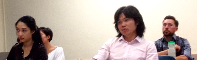 Students Yi Ding, Raymond Teoh, and faculy member Doug Johnson listen attentively to Aloisi's lecture.