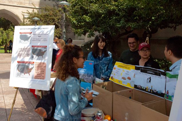 Ines Boussebaa (L) interviews Sustainability Planning Association members about their sustainability booth and event goals.