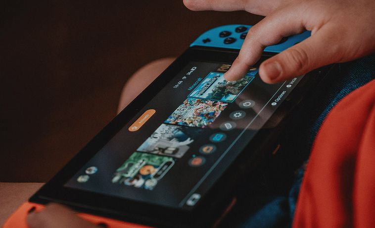 Child playing with Nintendo Switch gaming device.