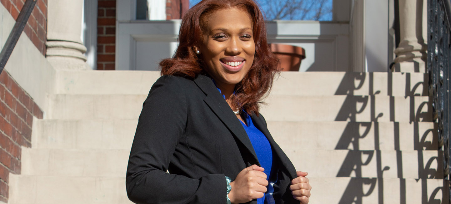 Nyah Jordan smiling portrait in front of staircase outdoors.