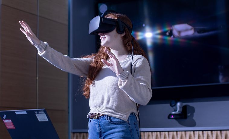 Student wearing virtual reality equipment in the Communication Research Center.