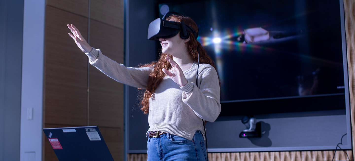 Student wearing virtual reality equipment in the Communication Research Center.