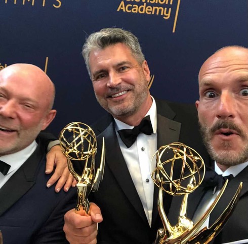 COM alum Michael Williams holding his Emmy Award.