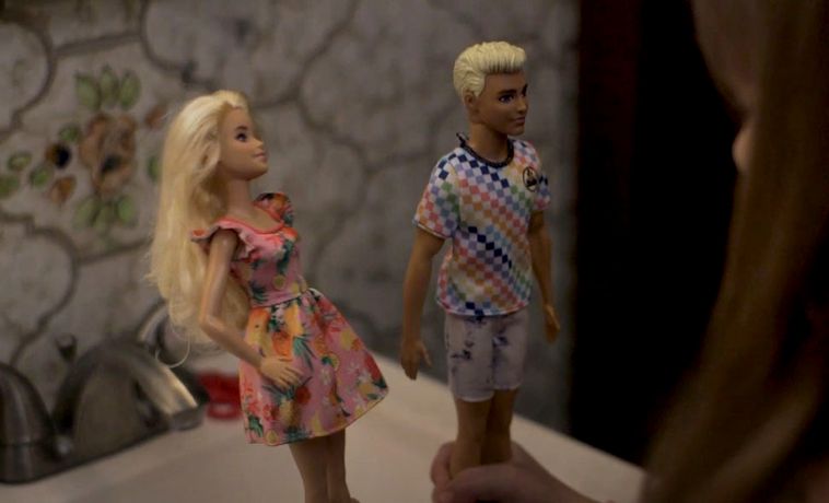 Child playing with dolls (Barbie and Ken).