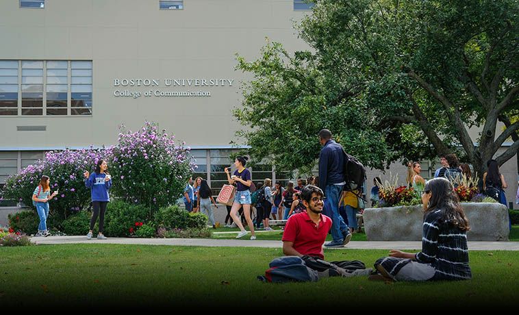 Students chatting while sitting on the COM Lawn.