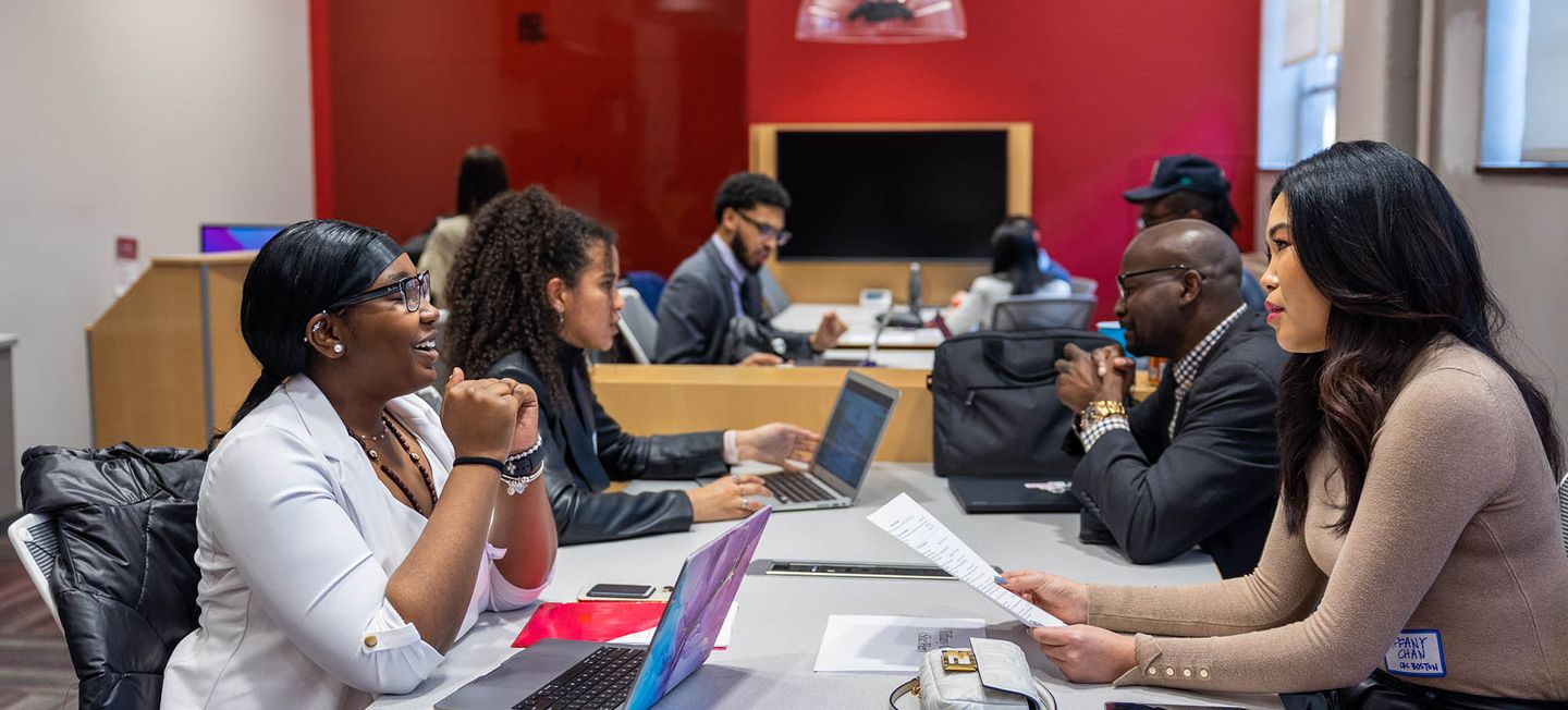 Students chatting with recruiters at a table.