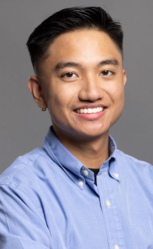Cauile, Josh standing with arms crossed, smiling, and posing for a photograph.