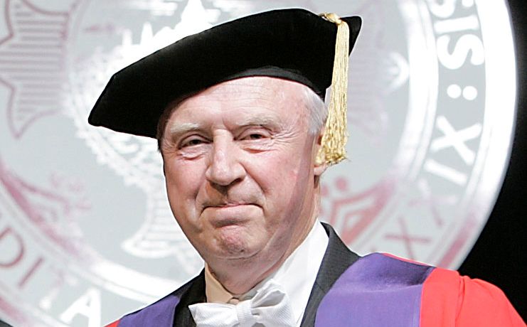 John Schulz wearing Commencement regalia.