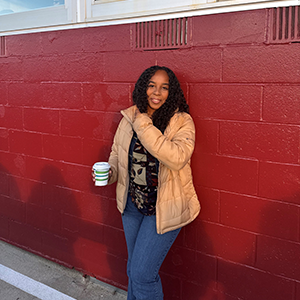 A photo of Madeleine Martin in front of a red wall. 