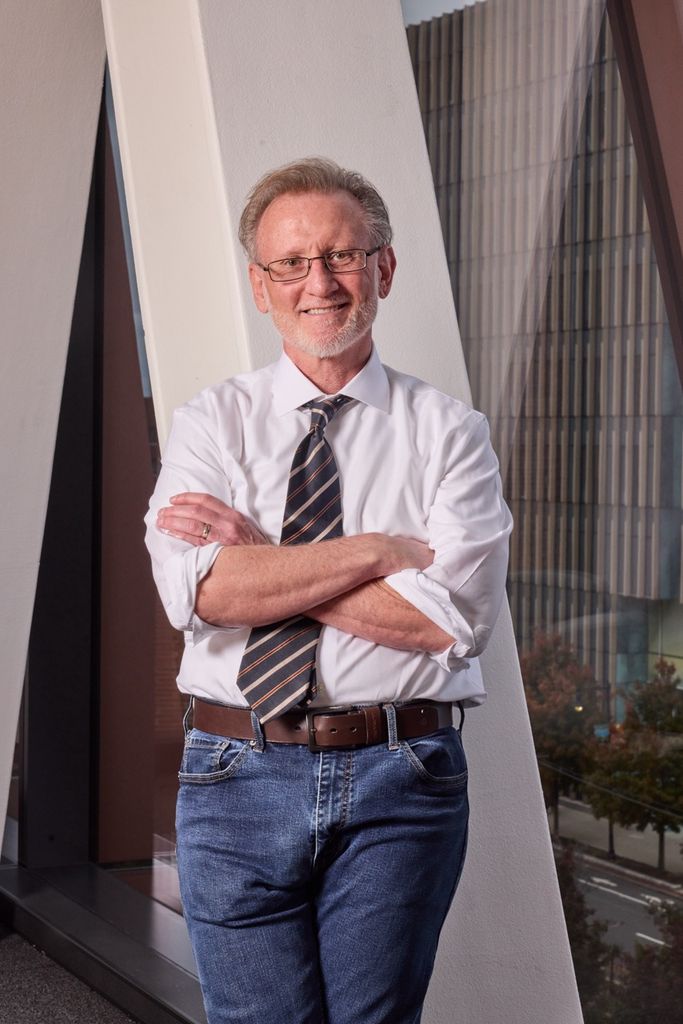 A photo of Professor Scott Farwell standing with his arms crossed.