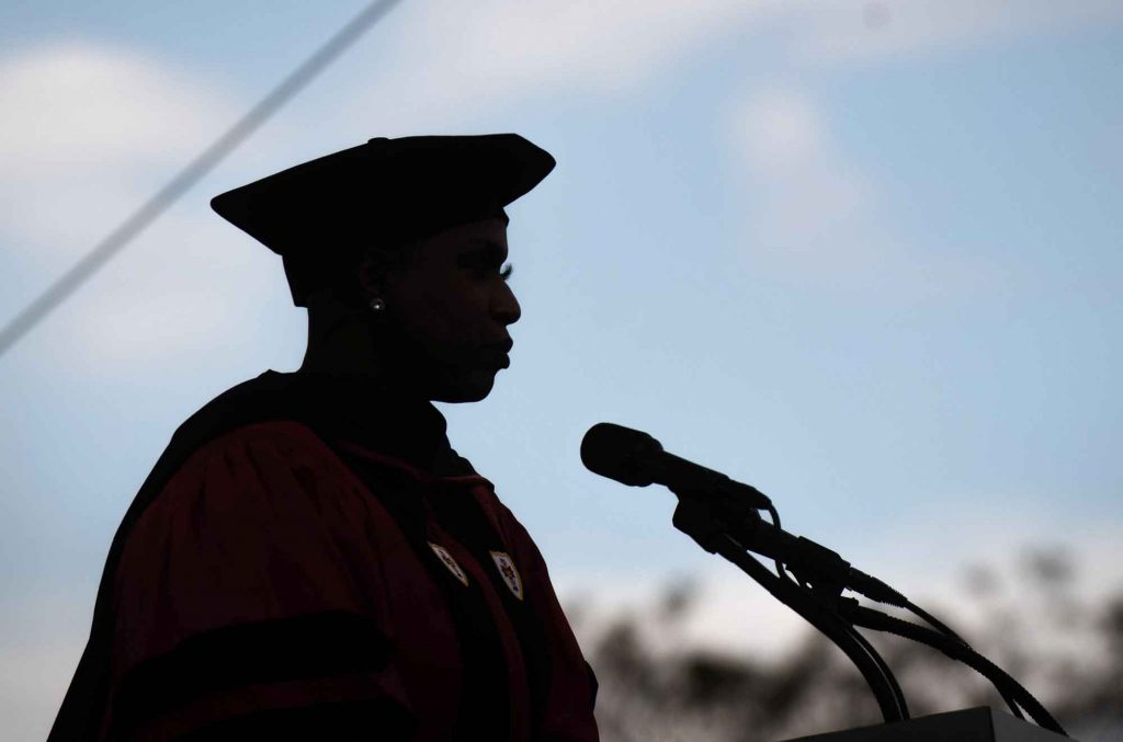 Silhouette of US Representative Ayanna Pressley against a blue sky as she delivers her address to graduating seniors at BU's 2021 Commencement for undergraduate degrees.