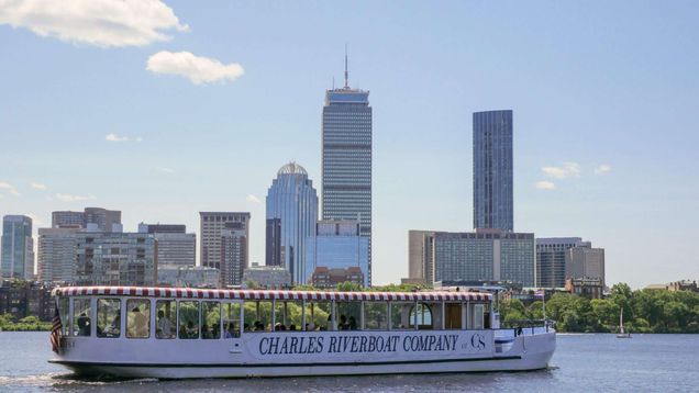 Charles River Boat Company boat with the Boston skyline in the background.