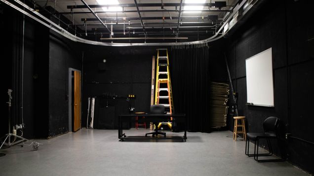 Image that shows the other side of Studio 100. It shows ladders, a white board and a swipe access door.