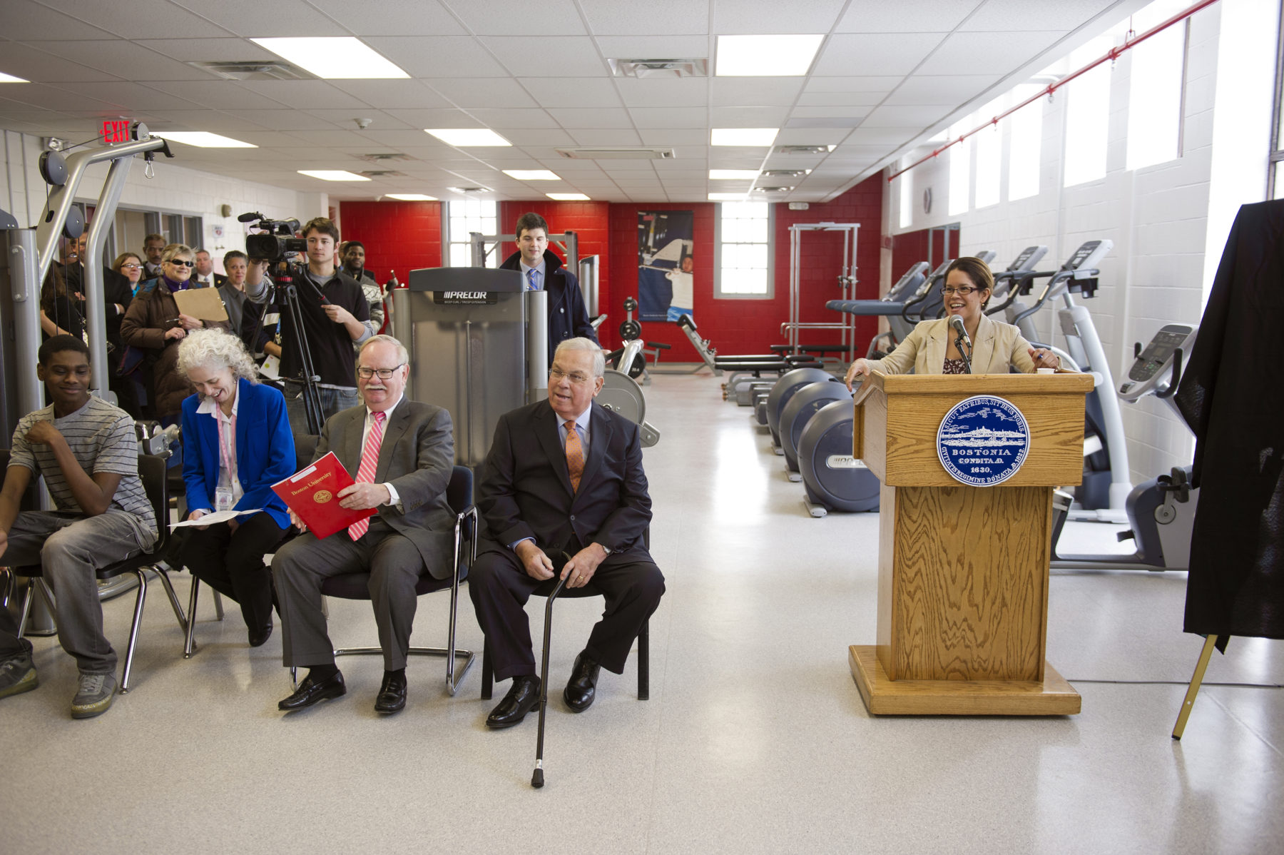 From left, Jamari Lewis, Barbara Ferrer, Executive Director of the Boston Public Health Commission, BU President Robert Brown, and Mayor Thomas Menino listen as Daphne Griffin, Chief of Human Service for the city of Boston speaks at the official opening of the Boston University Fitness and Wellness Center @ BCYF Blackstone. Photo by Cydney Scott for Boston University