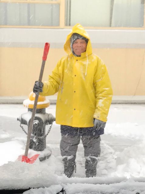 Anne Marie Philippe, a custodian and BU employee for 21 years, helps to clear a snow from a fire-hyrdrant on Comm Ave.