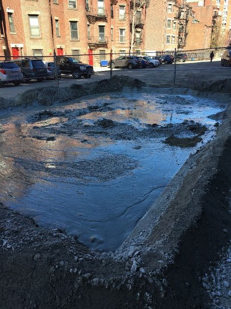 Drilling materials “spoils” settlement basin in alley
