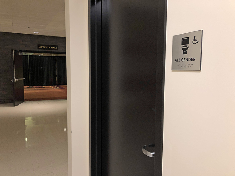 all gender bathroom sign mounted on wall