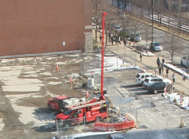 High-performance geothermal exchange vertical piping installation in parking lot