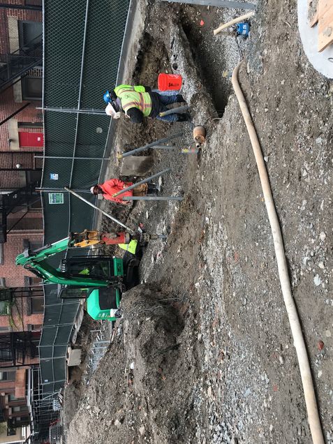 Drilling helical piles for the landscape wall between the brownstones and the Data Sciences building