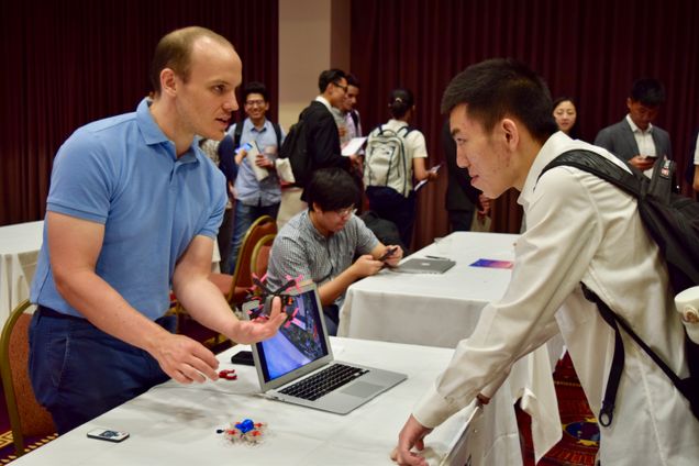 William Blair (CAS'12, GRS'14) discusses Boston Drone Racing with an interested student. Photo by Laura Knipe.