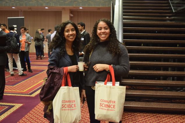 Two students pose with their CS Day swag bags. 