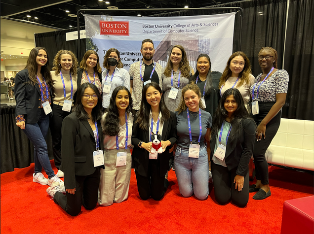 Boston University students pose in front of a Department of Computer Science banner at the Grace Hopper Celebration 2022.