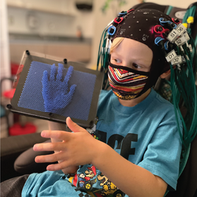 a child wearing neuroimaging headgear