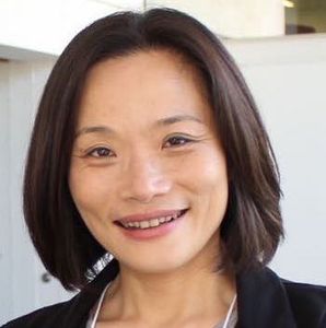 woman with short brown hair in front of a white background